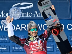 Éliot Grondin of Ste-Marie raises the Crystal Globe as the season's overall winner, Sunday, March 24, 2024, at the FIS snowboard cross world cup event in Beaupre.