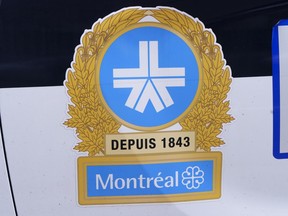 A montreal police logo on a police car. it's a blue star surrounding by gold floral imagery.