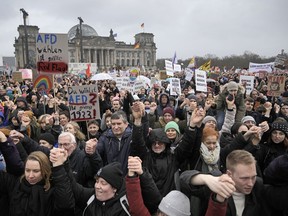 People hold hands in front of Germany's parliament at a demonstration against the far-right Alternative for Germany, or AfD, party and right-wing extremism in Berlin, Germany, Saturday, Feb. 3, 2024.