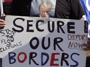 A man holds a sign during a "Take Our Border Back" rally on Feb. 3, 2024, in Quemado, Texas.