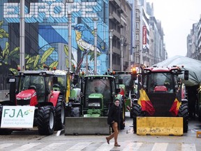 Tractors are parked behind a blockade in the European Quarter during a protest of farmers outside a meeting of EU agriculture ministers in Brussels, Monday, Feb. 26, 2024.