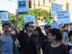 Protesters at a demonstration against new housing measures hold signs with messages including For a Future We Can Afford, No to Bill 31 and Say No to Unfair Rent Hikes.