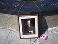 A framed portrait of former prime minister Brian Mulroney leans against the Centennial Flame on Parliament Hill as Canadians mourn his death at the age of 84, in Ottawa, on Friday, March 1, 2024.