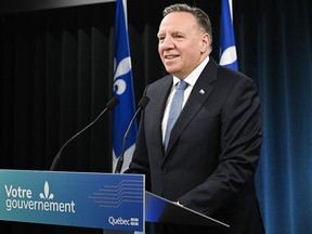 François Legault at a podium during a press conference.