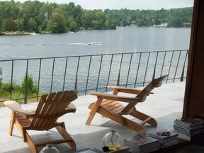 Two deck chairs on a balcony overlooking a lake