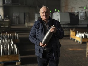Anatolli Kuzmin, the factory's 64-year-old owner, holds a mortar shell at a factory in Ukraine, on Wednesday, Jan. 31, 2024.