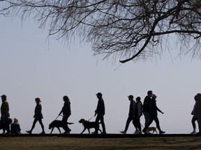 People walk along the boardwalk in Toronto's east end on Sunday, April 4 2021.