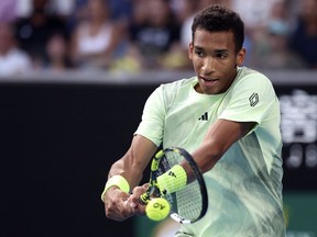 Montreal's Félix Auger-Aliassime plays a backhand return to Daniil Medvedev of Russia at the Australian Open tennis championships at Melbourne Park, Melbourne, Australia, on Jan. 20, 2024.