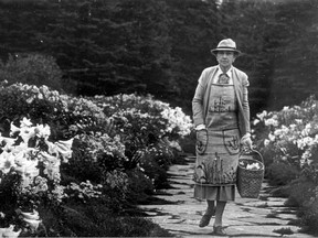 Black-and-white photo of a woman walking through a garden