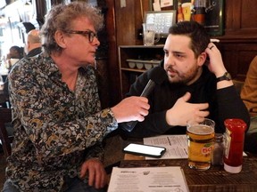 Gazette reporter Brendan Kelly interviews Canadiens fan Étienne Lebourdais at a table in McLean's Pub.