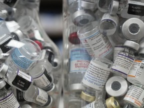 Jars full of empty COVID-19 vaccine vials are shown at a pharmacy in Toronto on Wednesday, April 6, 2022.