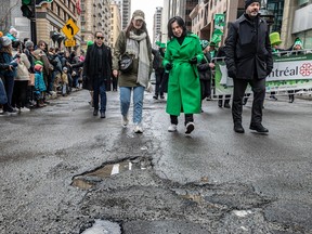 Valérie Plante in a green coat approaches a pothole during a parade