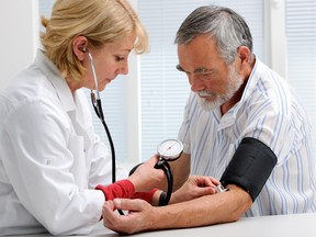 A health professional checks a man's blood pressure.