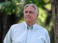 Keith Henderson looks off to the side while walking through a park