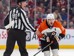 Flyers' Travis Konecny bends over in pain while skating past linesman Jonathan Deschamps after being slashed by Canadiens' Kaiden Guhle last week at the Bell Centre.