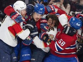 Canadiens' Arber Xhekaj, second from left, and David Savard tussle, right, with Panthers' Sam Bennett, left, and Ryan Lomberg during third-period action at the Bell Centre Tuesday night.