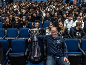 Alouettes general manager Danny Maciocia poses with the Grey Cup in front of about 280 students in the auditorium at his former high school, Laurier Macdonald in St-Léonard, on Wednesday.