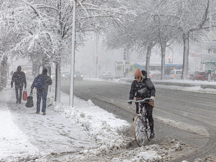 A cyclist makes her way through the snow on Atwater Ave. in Montreal on Thursday April 4, 2024.