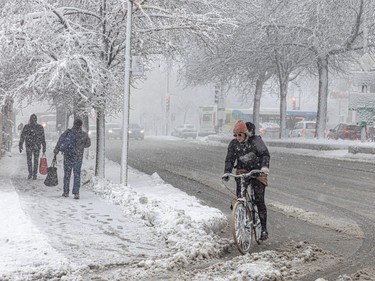 A cyclist turns on a street covered in snow and slush
