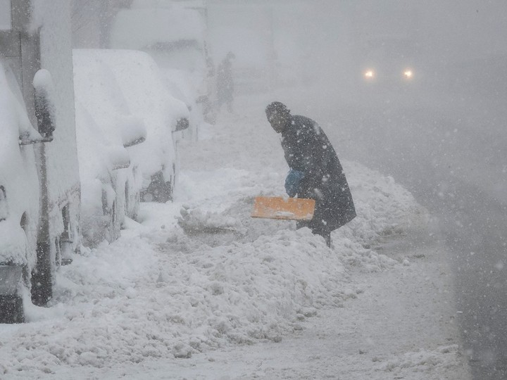 A Montrealer tries to clear his car on Papineau Ave. on Thursday April 4, 2024.