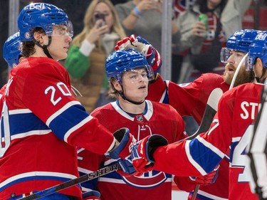 Montreal Canadiens' Cole Caufield gets a pat on the head from teammate David Savard