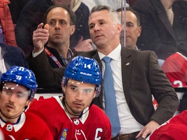 Martin St. Louis and Nick Suzuki watch from the bench with unhappy faces
