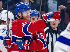 Canadiens' Joel Armia, wearing Montreal's home red jersey, points to an unseen teammate while being hugged by Alex Newhook after scoring a goal against the Lightning Thursday night at the Bell Centre.