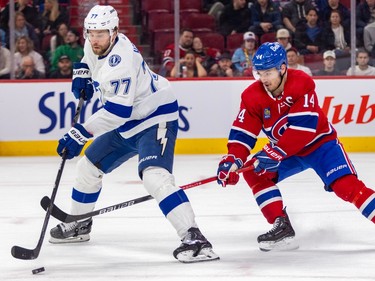 Montreal Canadiens' Nick Suzuki gets his stick between the legs of Tampa Bay Lightning's Victor Hedman as Hedman skates with the puck