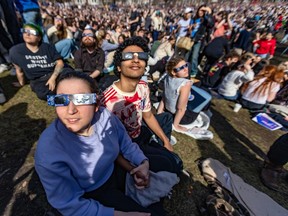Laurence Perreault, left, and Faris Ibntalib were among the thousands watching the eclipse on the McGill University campus Monday. (John Mahoney / MONTREAL GAZETTE)