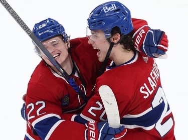 Two Canadiens players embrace on the ice while smiling