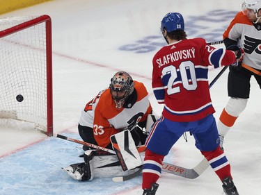 The puck is in the net behind the Flyers goaltender as Canadiens' Slafkovsky stands just outside the crease