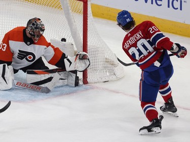 The puck is in the net behind the Flyers goaltender as Canadiens' Slafkovsky follows through on a shot beside the crease