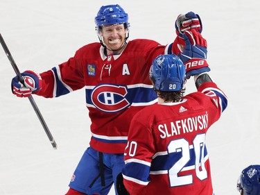 Juraj Slafkovsky high-fives a smiling Canadiens player on the ice