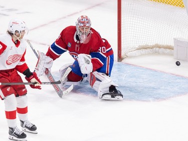 The puck is in the net behind Canadiens goalie Cayden Primeau as Red Wings' Patrick Kane skates by