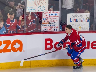 Logan Mailloux skates along the boards without his helmet while young fans hold up signs