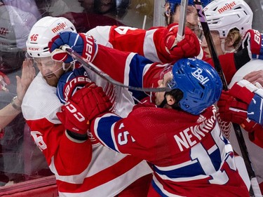 Canadiens' Alex Newhook and Red Wings' Jeff Petry jostle along the boards