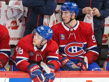 Canadiens defencemen Lane Hutson, left, and Logan Mailloux sit next to each other on the bench