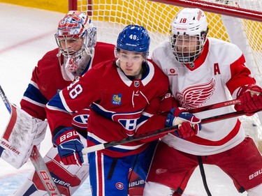 Lane Hutson jostles with Detroit Red Wings Andrew Copp in front of Canadiens goalie Cayden Primeau