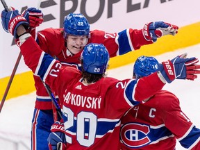 Canadiens' Cole Caufield leaps into Juraj Slafkovsky's arms, which are blocking the view of captain Nick Suzuki's face, after Slafkovsky scored his 20th goal in the season finale at the Bell Centre on Tuesday.