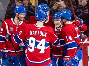 Teammates Mike Matheson, left, Logan Mailloux, Juraj Slafkovsky, rear, and Nick Suzuki, right, surround Canadiens' Cole Caufield after his goal against the Red Wings in the regular season finale at the Bell Centre last week.