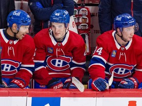 Canadiens defenceman, Lane Hutson, is flanked by Jayden Struble, left, and Logan Mailloux on the Habs bench.