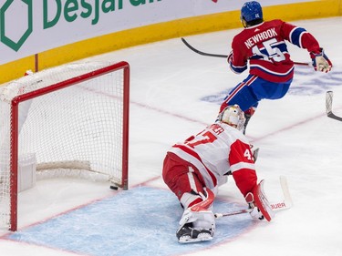 Alex Newhook skates away from the net while a puck sits inside it behind the Red Wings goalie