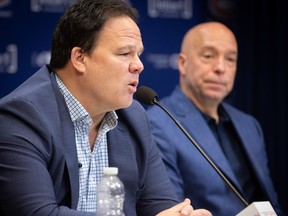 Canadiens executive vice-president of hockey operations Jeff Gorton, left, and GM Kent Hughes, both wearing blue jackets with shirts that have open collars, answer reporters' questions during the team's post-mortem Wednesday in Brossard.