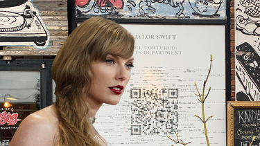 Composite photo of Taylor Swift in a white dress and a large QR code on the side of a building