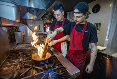 Chef Anderson Lee and line cook Simon Desbiens, right, prepare duck breast at Oncle Lee restaurant in Mile End on Thursday, April 18, 2024.