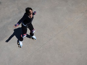 Overhead view of a woman listening to music as she wheels around on roller skates