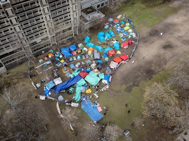 An aerial view of dozens of tents on a grassy area downtown