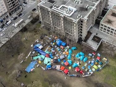 An aerial view of dozens of tents on a grassy area downtown
