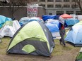 A person walks between tents set up at an encampment
