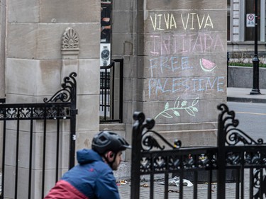 The message 'Viva viva intifada free Palestine' is written in chalk on the outside wall of a downtown building